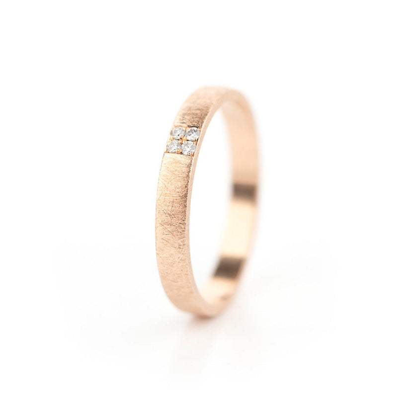 Een roodgouden trouwring met vier kleine diamanten