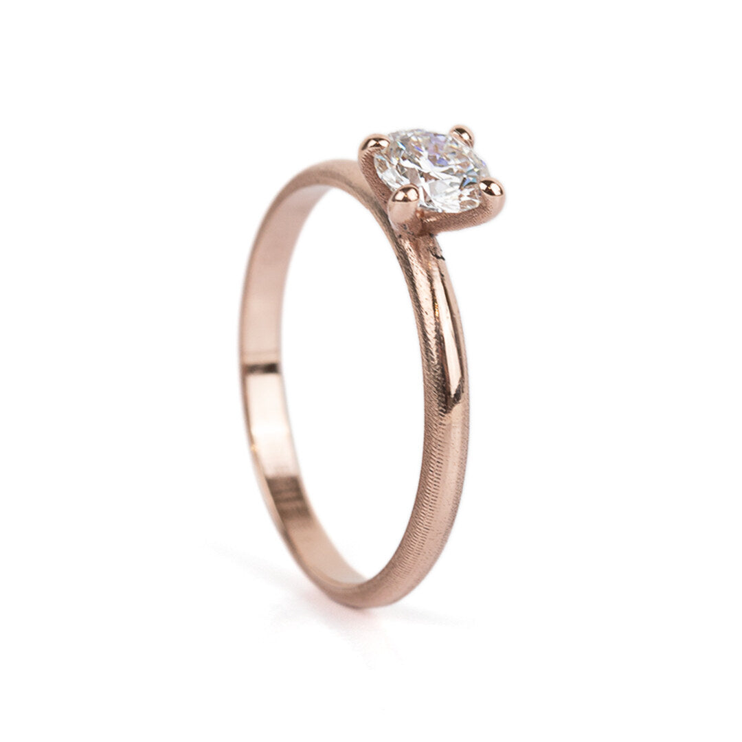 Een smalle roodgouden verlovingsring met één diamant