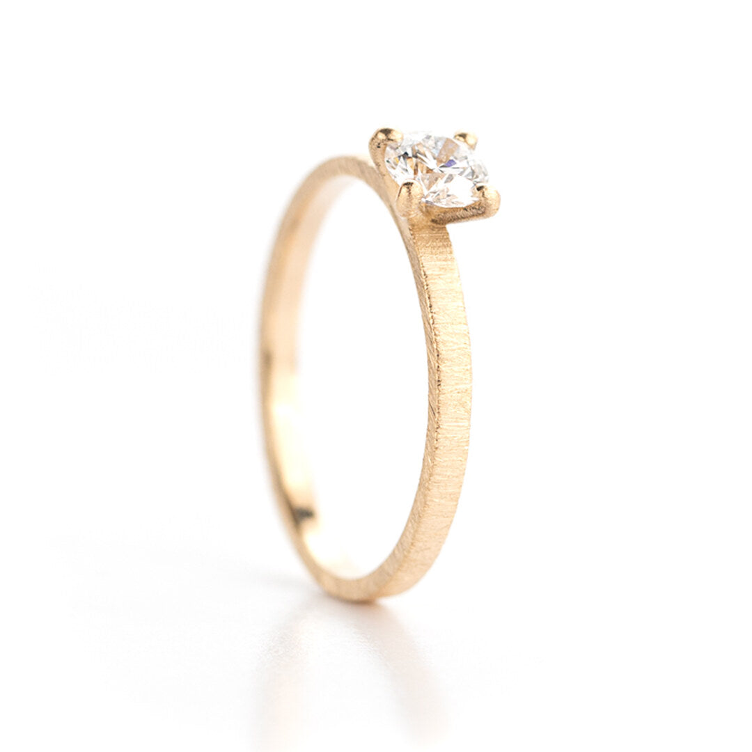 Een geborstelde geelgouden verlovingsring met één diamant